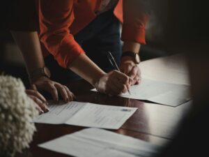 Close up of person signing a document