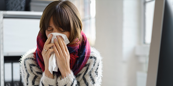 woman blowing into a tissue