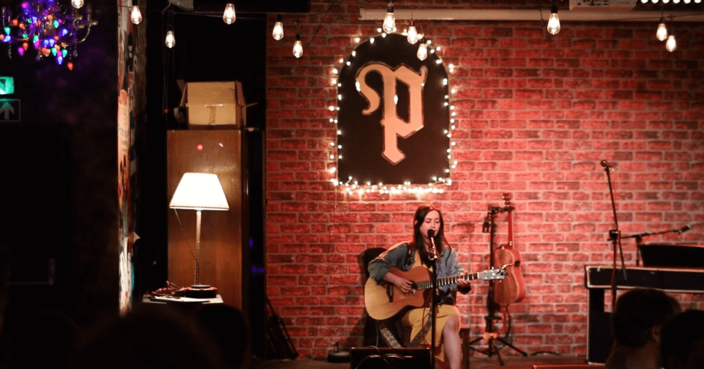 Singer with guitar on stage at Porter's